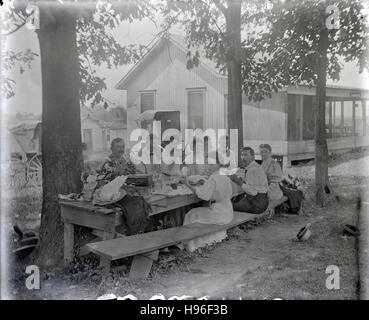 Meubles anciens c1900 photo, un groupe d'adultes ayant un déjeuner pique-nique à l'extérieur. Le signe sur la chambre dit "La Fayette.' localisation inconnue, probablement Midwest (USA) de l'Ohio ou de l'Indiana. SOURCE : négatif photographique original. Banque D'Images