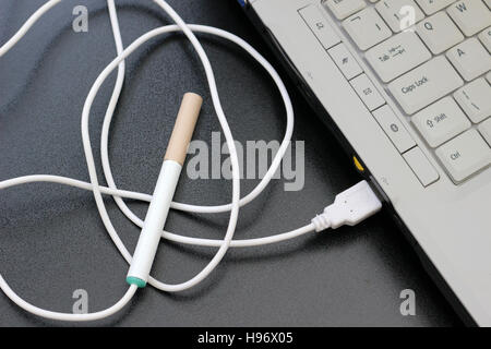 e-cigarette branché sur un port usb d'un ordinateur portable Banque D'Images