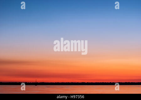 Coucher du soleil en mer avec des nuances d'orange, magenta et bleu dans le ciel Banque D'Images