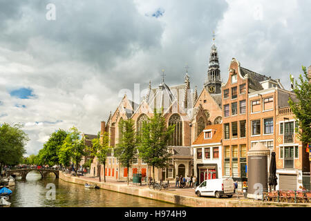 Amsterdam Red Light District canal avec l'ancienne église (aka la Oude Kerk) entre les maisons typiquement néerlandais, sur un matin d'été ensoleillé Banque D'Images