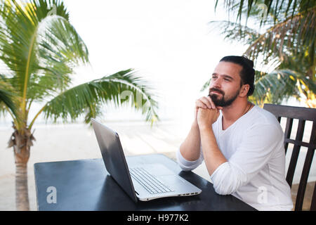 Le télétravail, homme d'affaires détente sur la plage avec ordinateur portable et palm, indépendant du travail, de l'emploi de rêve Banque D'Images