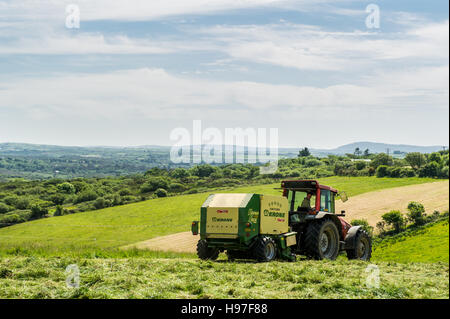 Un agriculteur irlandais prêt pour l'ensilage de balles rétractable en juin. Les bails sera utilisé comme alimentation de l'animal pendant les mois d'hiver. Banque D'Images