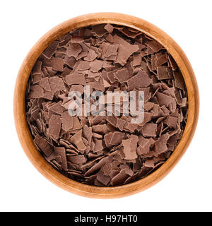 Chocolat au lait râpé dans un bol en bois. Brown copeaux de chocolat pour décorer les gâteaux, pâtisseries et biscuits. Macro photo alimentaire isolé Banque D'Images