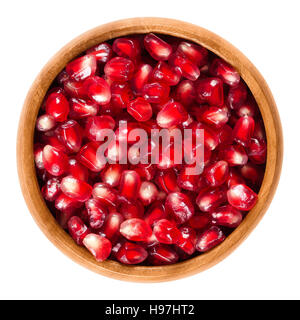 Les graines de grenade fraîche dans bol en bois. Graines rouge comestible du fruit de Punica granatum, séparés de l'écorce. Banque D'Images