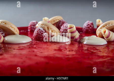 Décoration avec des framboises, des chocolats et des biscuits sur un gâteau Banque D'Images