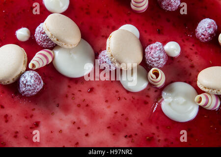 Décoration avec des framboises, des chocolats et des biscuits sur un gâteau Banque D'Images