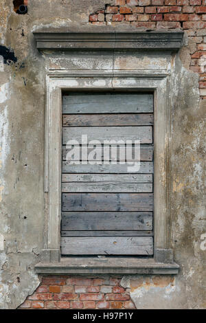 Vieux, barricadés dans la fenêtre mur en ruine d'une ancienne maison de maître Banque D'Images