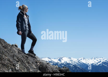 Une femme athlétique active se dresse sur le sommet d'une montagne Banque D'Images