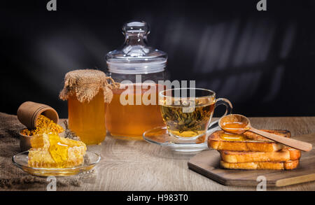 Des toasts avec du miel et du thé dans le style rustique Banque D'Images