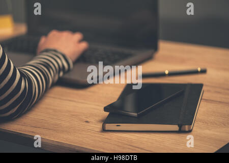 Mobile smartphone et ordinateur portable sur office desktop, selective focus Banque D'Images