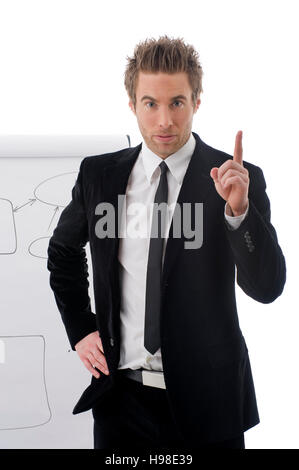 Jeune homme debout devant un tableau à feuilles mobiles Banque D'Images