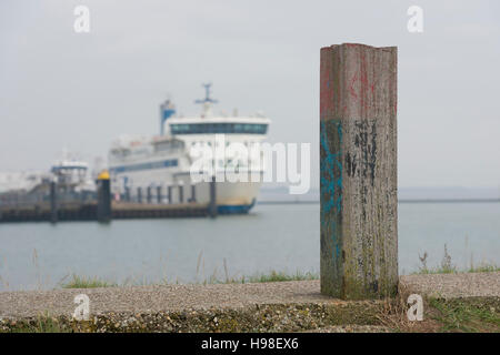 Bollard sur la digue de Terschelling avec un ferry en arrière-plan Banque D'Images