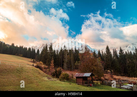 Un chalet de montagne dans la vallée au cours d'un lever de soleil coloré Banque D'Images