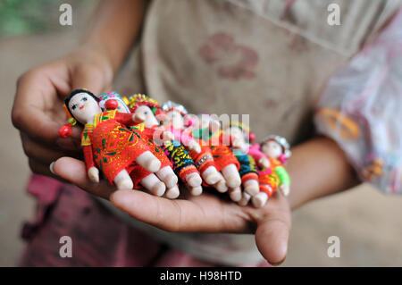 Un enfant lao Hmong vend des poupées porte-clé à Luang Prabang, Laos. Banque D'Images