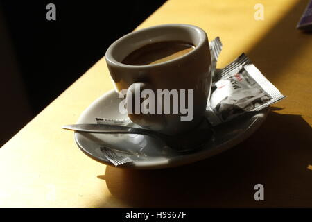 Une tasse de café sur la table dans le soleil. Banque D'Images