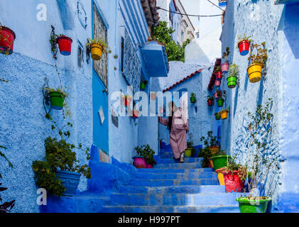 Une vieille femme marchant dans une rue pittoresque de la médina, Chefchaouen, Maroc Banque D'Images