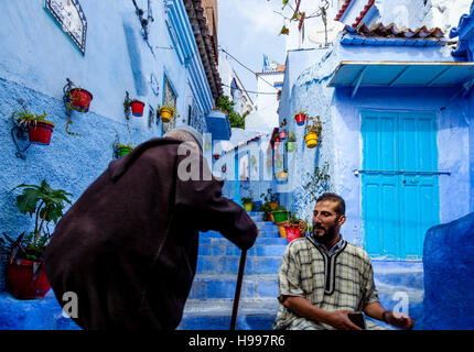 Un homme âgé à monter une rue colorée dans la médina, Chefchaouen, Maroc Banque D'Images
