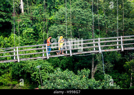 Personnes marchant sur un pont suspendu, traversant la rivière Bahorok à Bukit Lawang, Bahorok, Langkat, Sumatra Nord, Indonésie. Banque D'Images