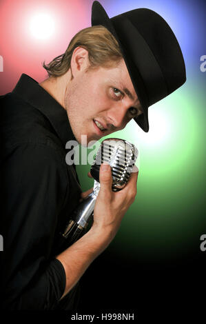 Bel homme le chant avec un microphone vintage Banque D'Images