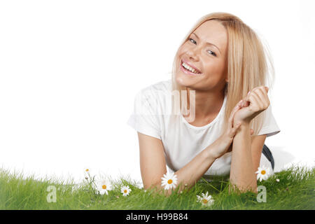 Happy young woman lying on grass avec fleurs de camomille, isolé sur fond blanc Banque D'Images