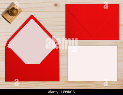Ensemble d'enveloppes rouges, avec tampon de caoutchouc et de carte. Collection sur fond de bois clair. Banque D'Images