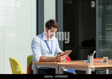 Young businessman in office using digital tablet Banque D'Images