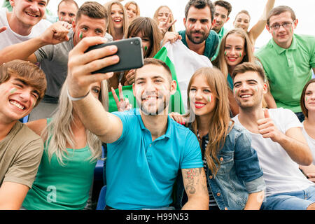 Groupe de fans dans le stade en prenant un selfies Banque D'Images