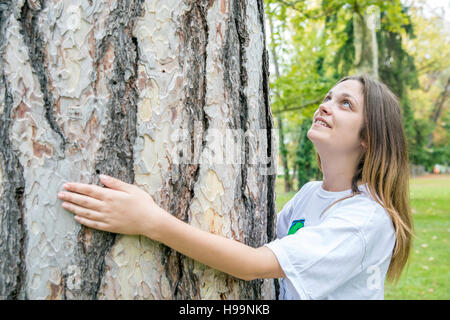 L'environnementaliste adolescentes hugging tree Banque D'Images