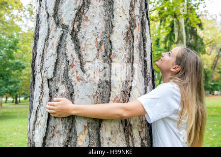 L'environnementaliste adolescentes hugging tree Banque D'Images