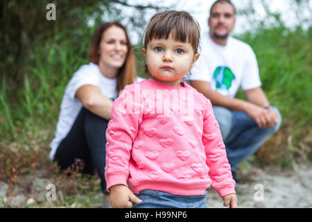 Bébé fille avec les parents en arrière-plan Banque D'Images