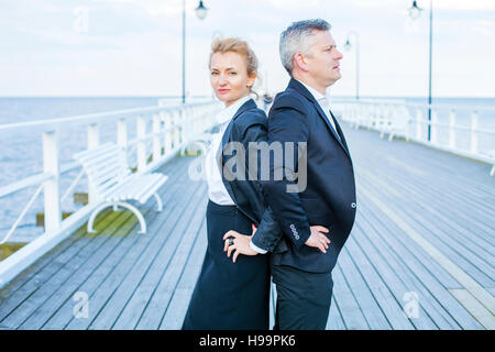 Deux hommes d'affaires on jetty with hands on hips Banque D'Images