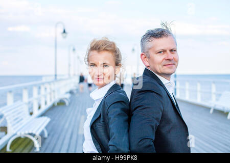 Deux hommes d'affaires on jetty with hands on hips Banque D'Images