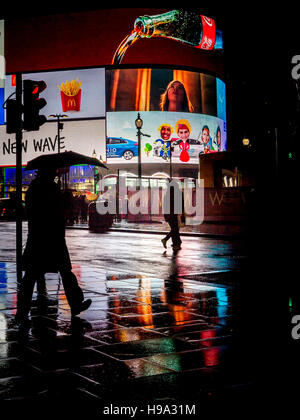 La pluie reflète Piccadilly Circus lumières dans le centre de Londres Banque D'Images