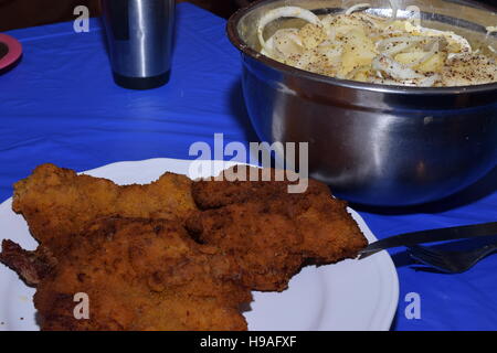 Wiener Schnitzel sur une plaque blanche avec un bol en argent de la salade de pommes de terre Banque D'Images