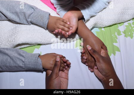 Plus girl holding frères et sœurs plus jeunes' hands Banque D'Images