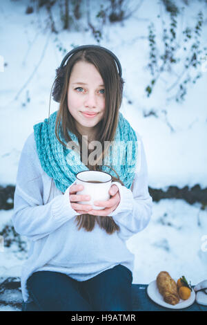 Belle femme de boire une boisson chaude en hiver Parc. Vacances d'hiver. Focus sélectif. Banque D'Images