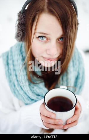 Jeune femme séduisante de boire du thé en plein air en hiver, selective focus Banque D'Images