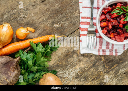 Légumes crus et vinaigrette salade fraîche sur un fond rustique vue d'en haut. Banque D'Images