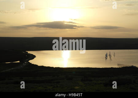 Coucher du soleil jaune sur l'extrémité sud de Warley Moor réservoir, avec cinq dériveurs, South Pennines, Halifax, West Yorkshire, Banque D'Images