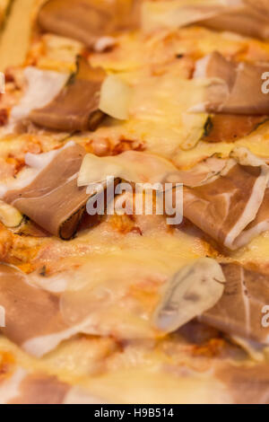 Close up of hand made fête viande italienne pizza au fromage fondu, de tomate, de charcuterie et de garniture de bacon Banque D'Images