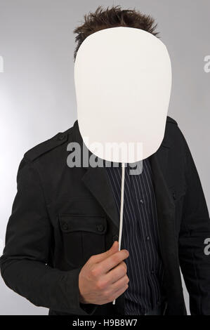 Young man holding blank bouclier en face de son visage Banque D'Images