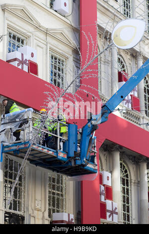 Les hommes de travail de mettre en place les décorations de Noël à la boutique Cartier à Londres Banque D'Images