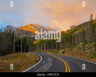 Les sommets s'allumer au lever du soleil le long de la route du lac de l'ours dans le Parc National des Montagnes Rocheuses. Banque D'Images