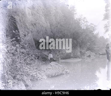 C Antique1900 photographie, l'homme debout près de petit cours d'eau et de falaises. Lieu inconnu, peut-être Hoosier National Forest, Indiana, USA. SOURCE : négatif photographique original. Banque D'Images