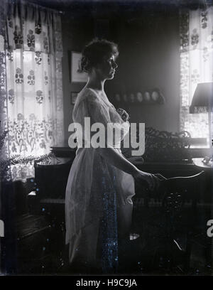 Meubles anciens c1900 photo, woman in profile en face de piano. SOURCE : négatif photographique original. Banque D'Images