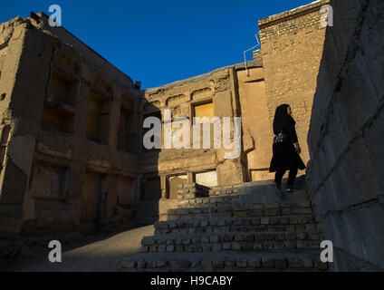 Une fille iranienne des promenades dans les maisons en ruine de l'ancienne partie de la ville, province d'Ispahan, Isfahan, Iran Banque D'Images