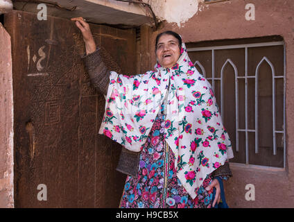 Portrait d'une femme iranienne vêtu du costume traditionnel floreal tchador devant une vieille porte en bois, comté de Natanz, l'Iran, Abyaneh Banque D'Images