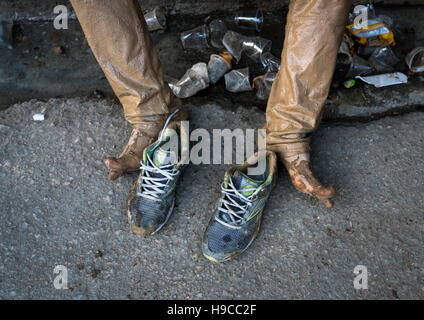 L'homme musulman chiite iranien les jambes et les chaussures après frottement de la boue sur ses vêtements pendant le rituel kharrah le Mali à l'occasion de la cérémonie d'Ashura, Lorestan provinc Banque D'Images