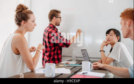 Casual young business man faisant office de présentation. Une présentation de la direction des affaires à ses collègues au cours de réunion, expliquant le bus Banque D'Images