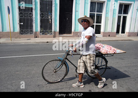 Un homme vend des gâteaux à la crème de l'arrière de sa bicyclette le long des rues de Cienfuegos Cuba Banque D'Images